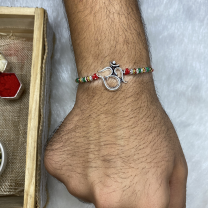 A man Silver Rakhi for brother with Thread and Silver motif of Classic Om