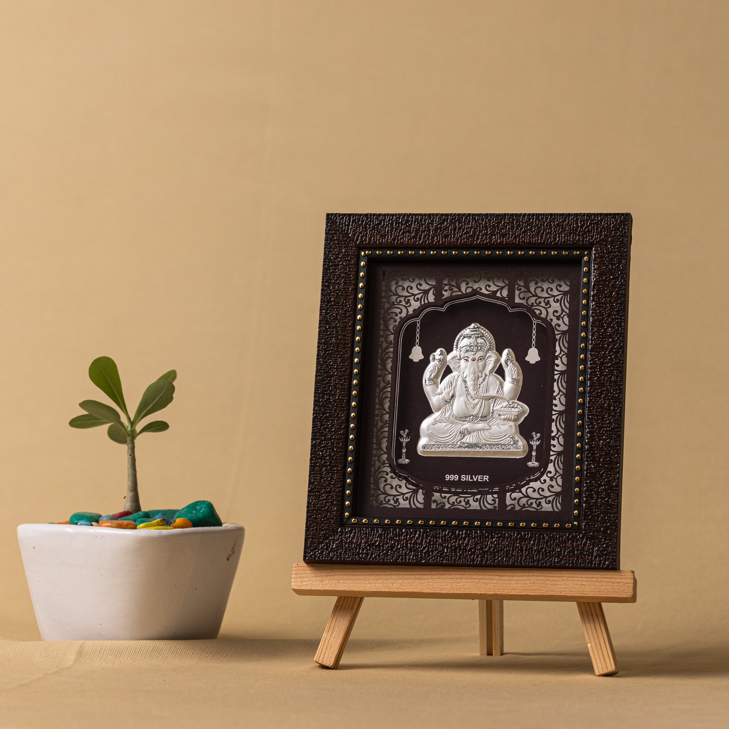 "Angled view of the pure silver Ganesh frame by Hem Jewels® placed on a wooden table."