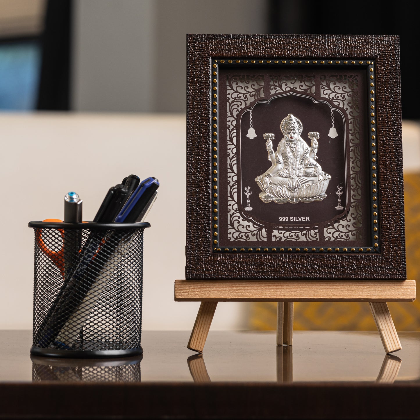 "Front view of pure silver Laxmi frame by Hem Jewels® placed on a table."	