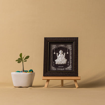 "Angled view of the pure silver Laxmi frame by Hem Jewels® placed on a wooden table."	