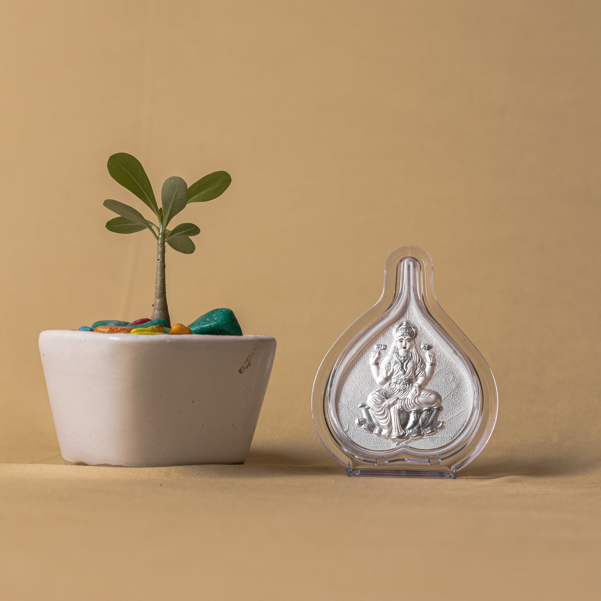 "Angled view of the pure silver Laxmi frame by Hem Jewels® placed on a wooden table."	