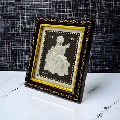 "Angled view of the pure silver Saraswati frame by Hem Jewels® placed on a wooden table."	