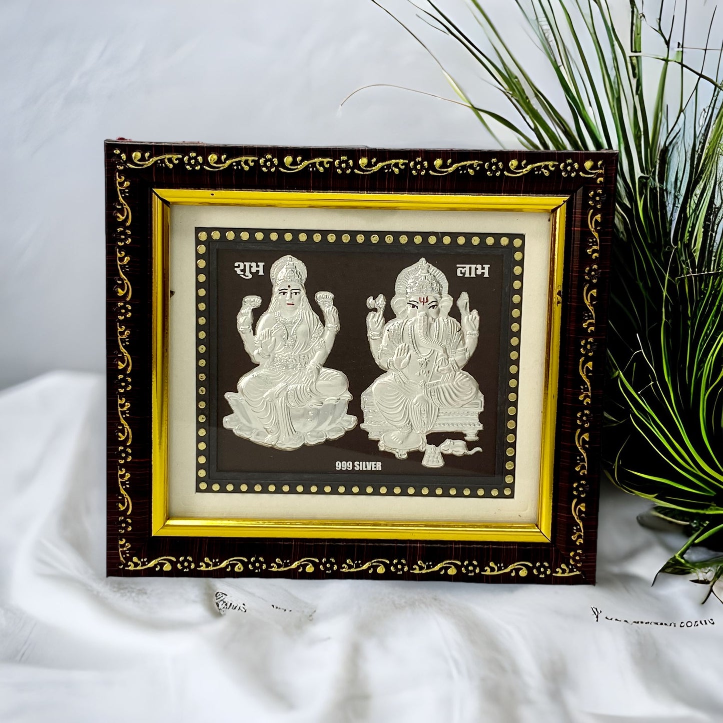 "Front view of pure silver Ganesh Laxmi frame by Hem Jewels® placed on a table."	