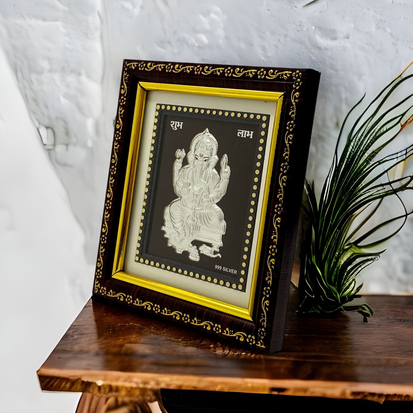 "Angled view of the pure silver Ganesh frame by Hem Jewels® placed on a wooden table."