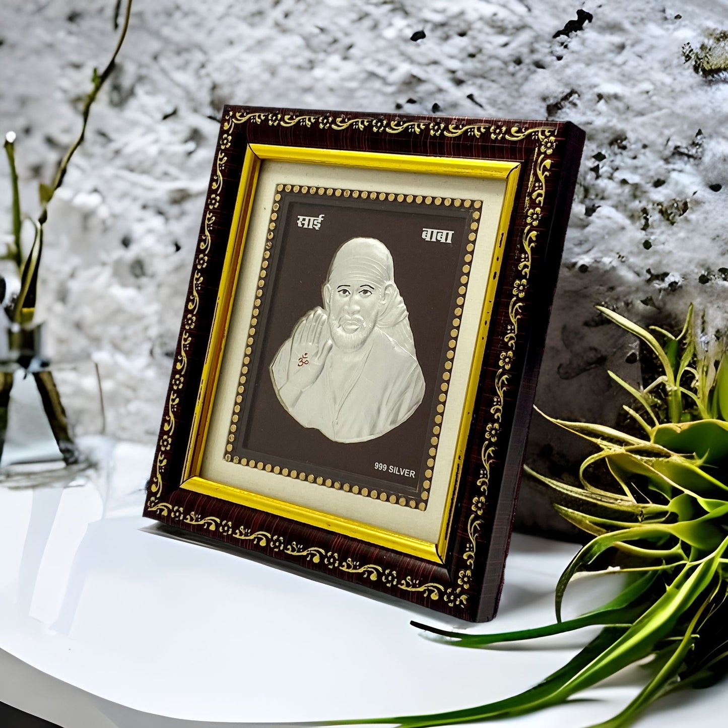 "Angled view of the pure silver Sai Baba frame by Hem Jewels® placed on a wooden table."	